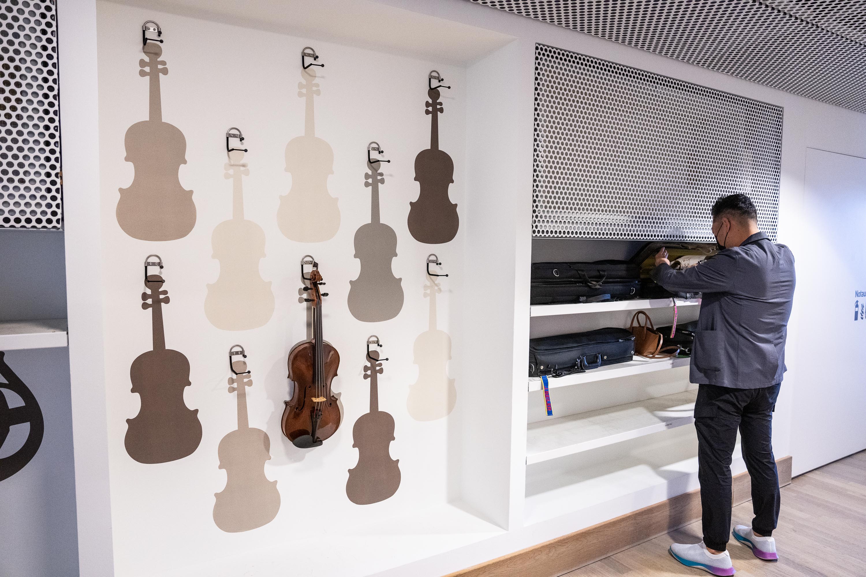 Violist Marvin Moon grabs something from his instrument case backstage at the Elbphilharmonie Hamburg