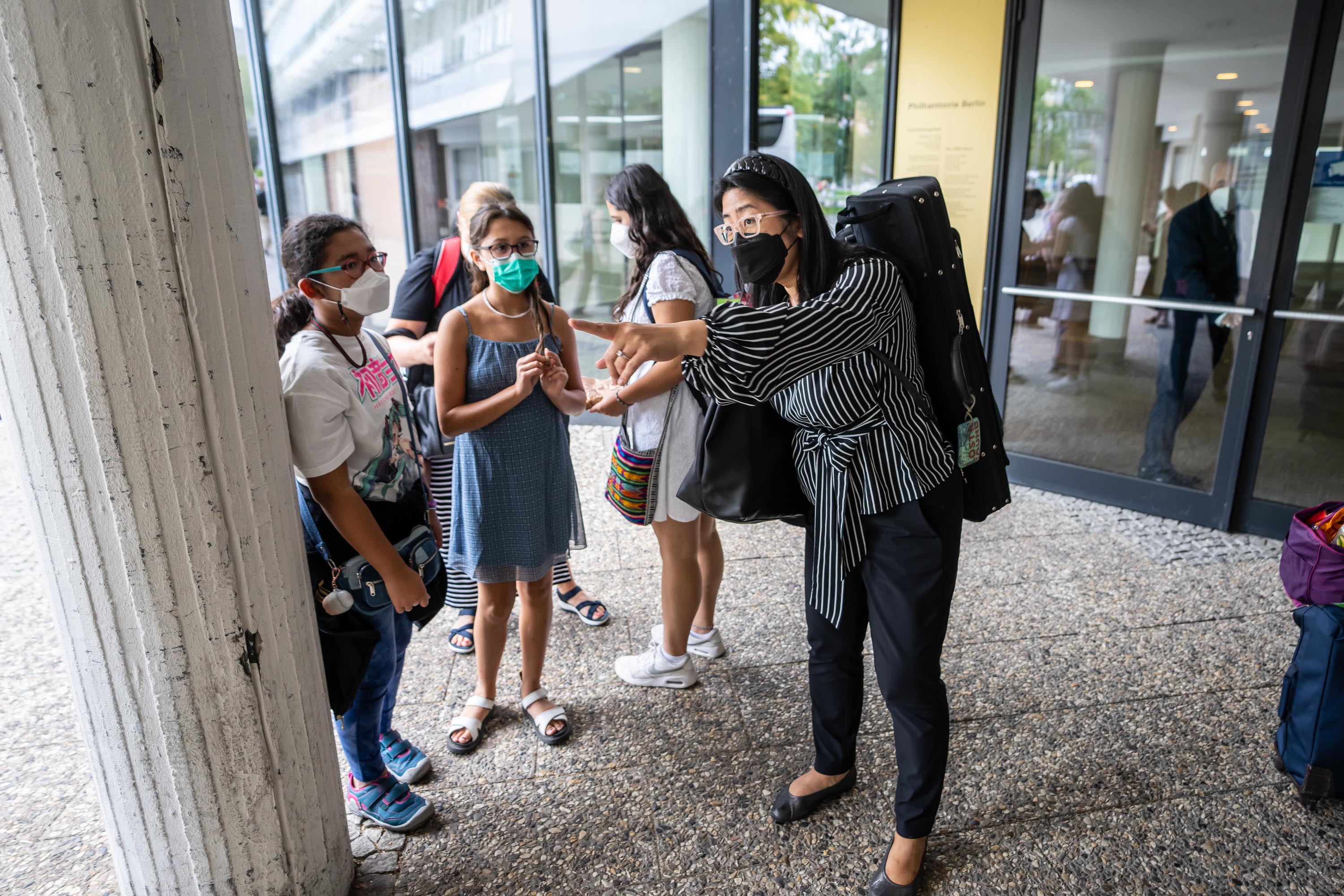 Violinist Amy Oshiro-Morales shows her daughter and niece where to meet outside the concert hall following the performance