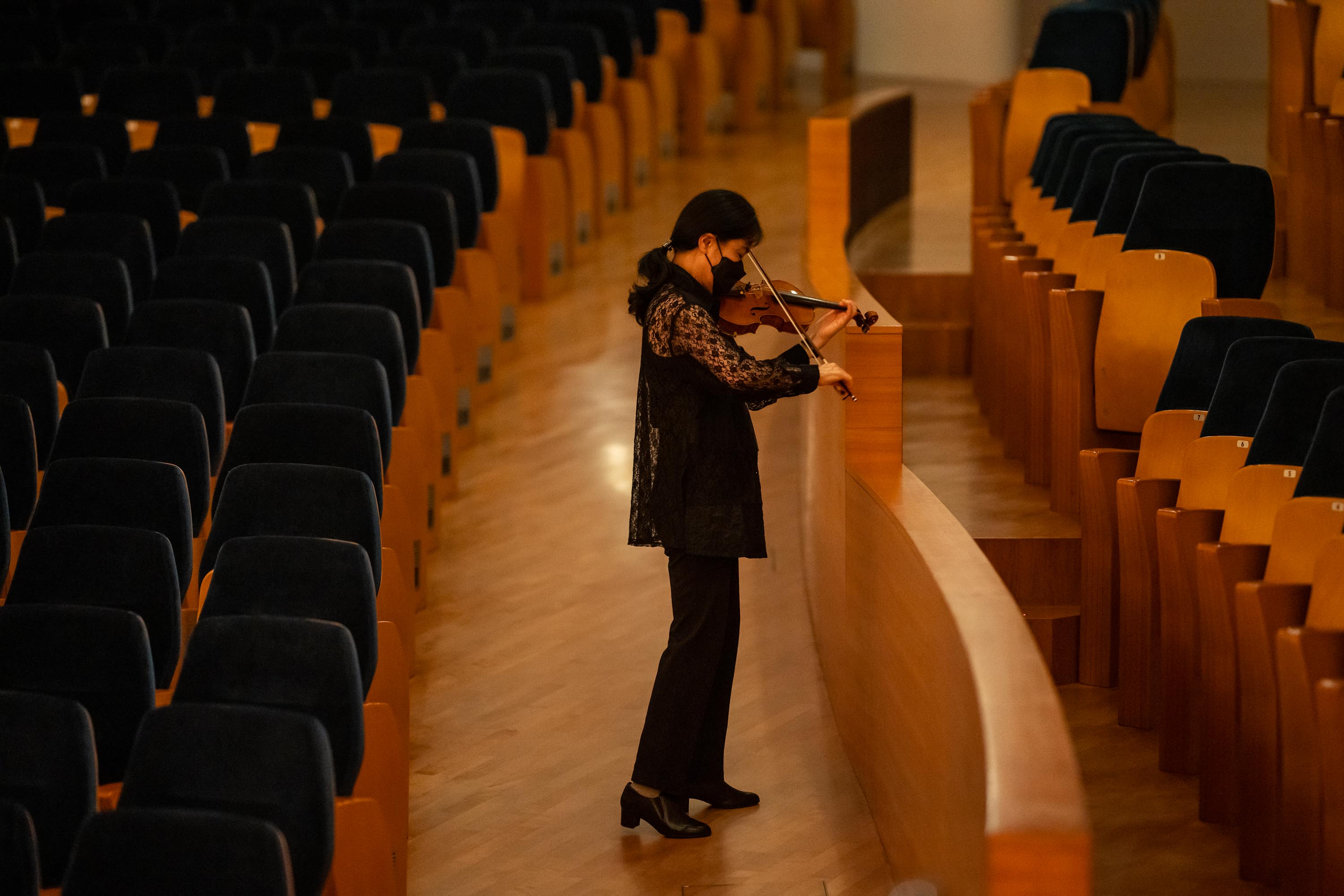 Violinist Hirono Oka warms up in the auditorium 