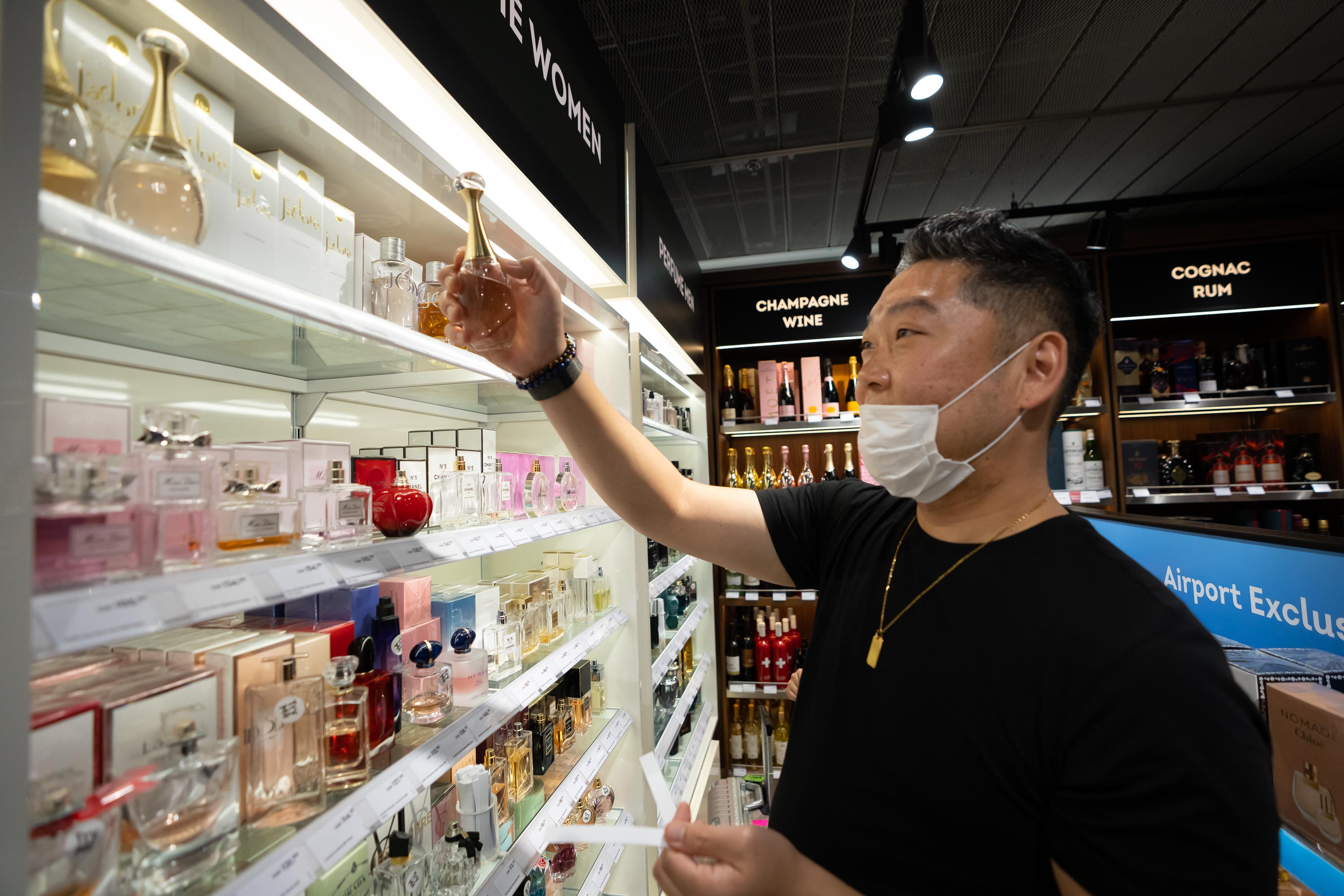 Violist Marvin Moon decides on a perfume purchase at the Duty Free Shop