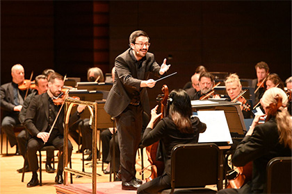 Conductor Austin Chanu conducting the Philadelphia Orchestra on stage.