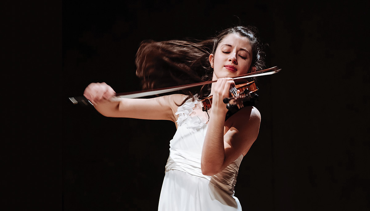 María Dueñas posing with a violin.