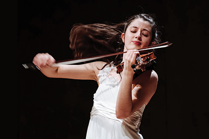 María Dueñas posing with a violin.