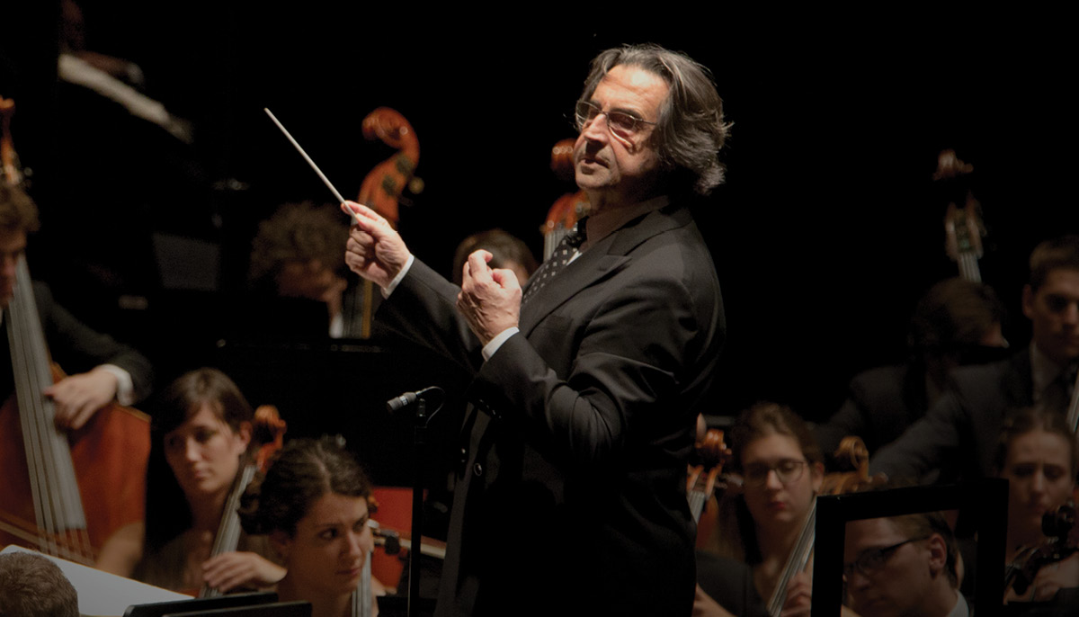 Conductor Riccardo Multi conducting an orchestra.