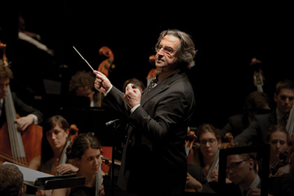 Conductor Riccardo Multi conducting an orchestra.