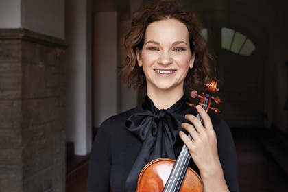 Musician Hilary Hahn posing with a violin.